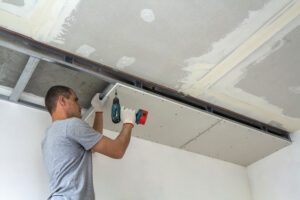 guy putting up drywall - commercial drywall contractors near me