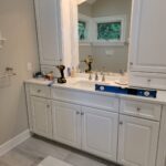 Bathroom remodeled with fresh light cabinets and backlit vanity