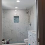 white kitchern with light glossy flor tiling, matching shower backsplash