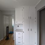 white storage pantry cabinets with chrome fixtures