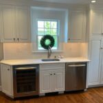 White marble countertops with white cabinet and stainless steel fixtures and appliances in modern kitchen by LaClave Home Improvements