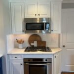 white kitchen cabinetry with stainless steel fixtures
