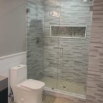 varied grey tile shower back splash and large glass shower enclosure