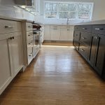 Modernized kitchen with dual tone cabinetry and light wood floors